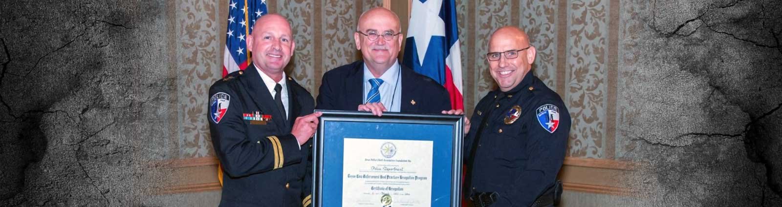 Three men in uniform holding award from TPCA Recognition Program